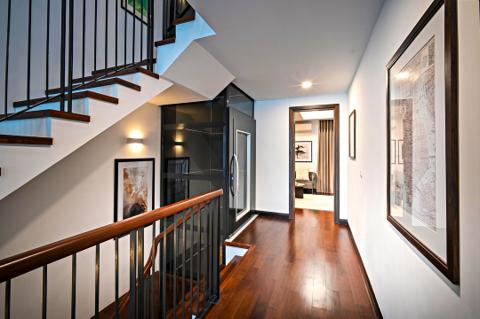 A wooden staircase with black metal railings and polished wood handrails, leading both upward and downward, indicating a multi-story home.